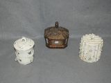 three small ceramic containers sitting on top of a gray surface