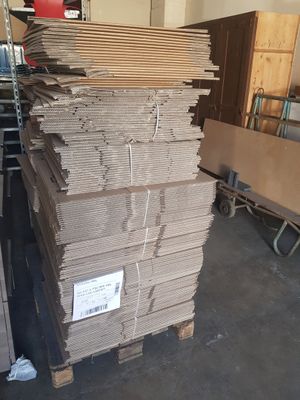 several stacks of cardboard stacked on top of each other in a warehouse