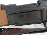an old machine gun with a wooden handle on a white surface