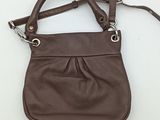 a brown leather purse with a strap hanging from it ' s side