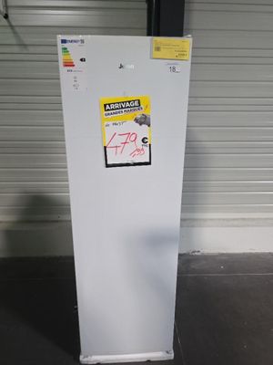 un réfrigérateur blanc sur lequel est collé un autocollant, dans un garage