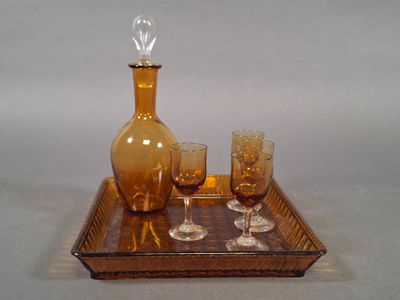 Les bouteilles et les verres sont posés sur un plateau sur lequel se trouve une carafe en verre.