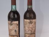 deux bouteilles de vin posées l'une à côté de l'autre sur une surface blanche