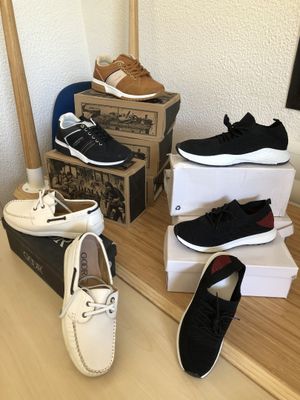 several pairs of men ' s shoes sitting on top of a wooden table