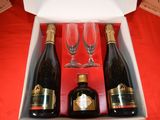 three bottles of wine and two glasses in a box