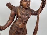 a wooden statue of a man holding a staff