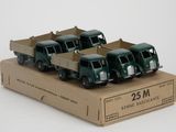 quatre camions miniatures dans une boîte en carton posée sur une surface blanche