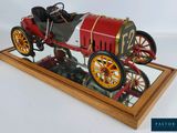 a model of a red and white car on a wooden stand
