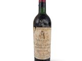 une vieille bouteille de vin posée sur une surface blanche