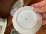 a person holding a white plate with a blue flower on it