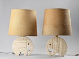 pair of wooden elephant table lamps with lampshads on top of them