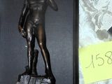 une photo représentant la statue d'un homme sur un rocher