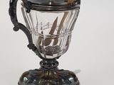 a silver cup with a handle and a spoon on it