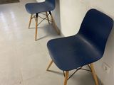 two blue chairs sitting next to each other in a room