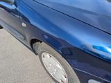 a blue car that is parked on the side of the road