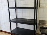 une étagère noire dans une cuisine équipée d'un évier et d'une cuisinière