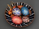 a bowl filled with different colored eggs on a table