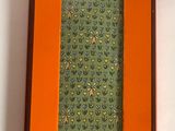 an orange box with a green tie sitting on top of a white table