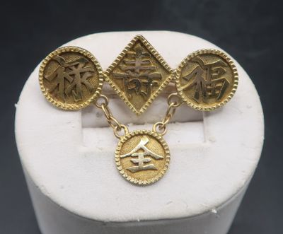 a close up of a pair of gold earrings on top of a white box