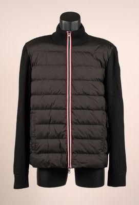 une veste noire avec une bande rouge, blanche et bleue sur le côté