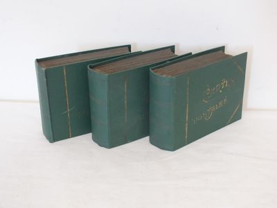 trois livres verts posés sur une surface blanche