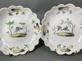 deux assiettes ornées d'oiseaux et de palmiers sur un fond gris