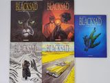 trois livres posés sur une table blanche, avec un chat et une voiture