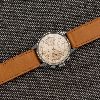 une image représentant une montre avec un bracelet en cuir marron sur un fond noir