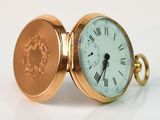 une montre de poche en or avec des chiffres romains