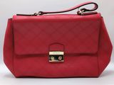 a red handbag with a gold lock on the handle
