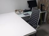 un bureau avec un ordinateur et une chaise dans une pièce