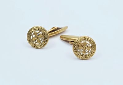 deux paires de boutons de manchette en or sur fond blanc