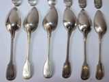 six spoons and six spoons sitting on a table