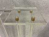 a glass table with four candles on top of it