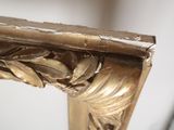 a close up of a gold frame with a mirror in the background