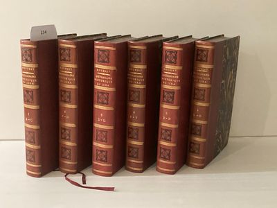 six livres sont alignés sur une surface blanche