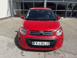 La petite voiture rouge est garée devant un immeuble.
