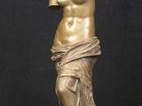 a bronze statue of a woman holding a vase