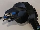 a black power cord plugged into a white wall