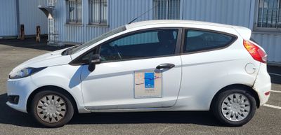 une petite voiture blanche garée dans un parking
