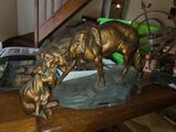 une statue en bronze représentant un chien et un chat posée sur une table