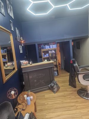une photo d'un salon de coiffure aux murs bleus et au parquet