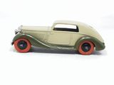 a green toy car with orange wheels on a white surface