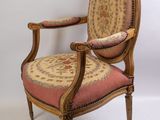 une image représentant une chaise en bois dont l'assise est recouverte d'un tissu rouge et beige