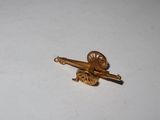 a small gold object on a white surface