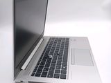 a silver laptop with a black keyboard on a white surface