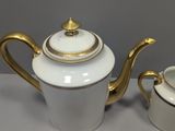 a white and gold tea set on a table