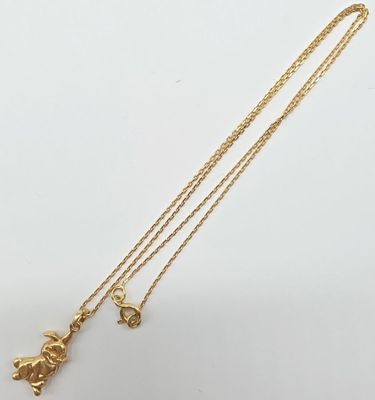 a gold plated necklace with a small elephant charm on a gold chain