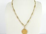 a close up of a necklace with a coin on a mannequin