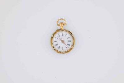 a close up of a gold pocket watch on a white surface